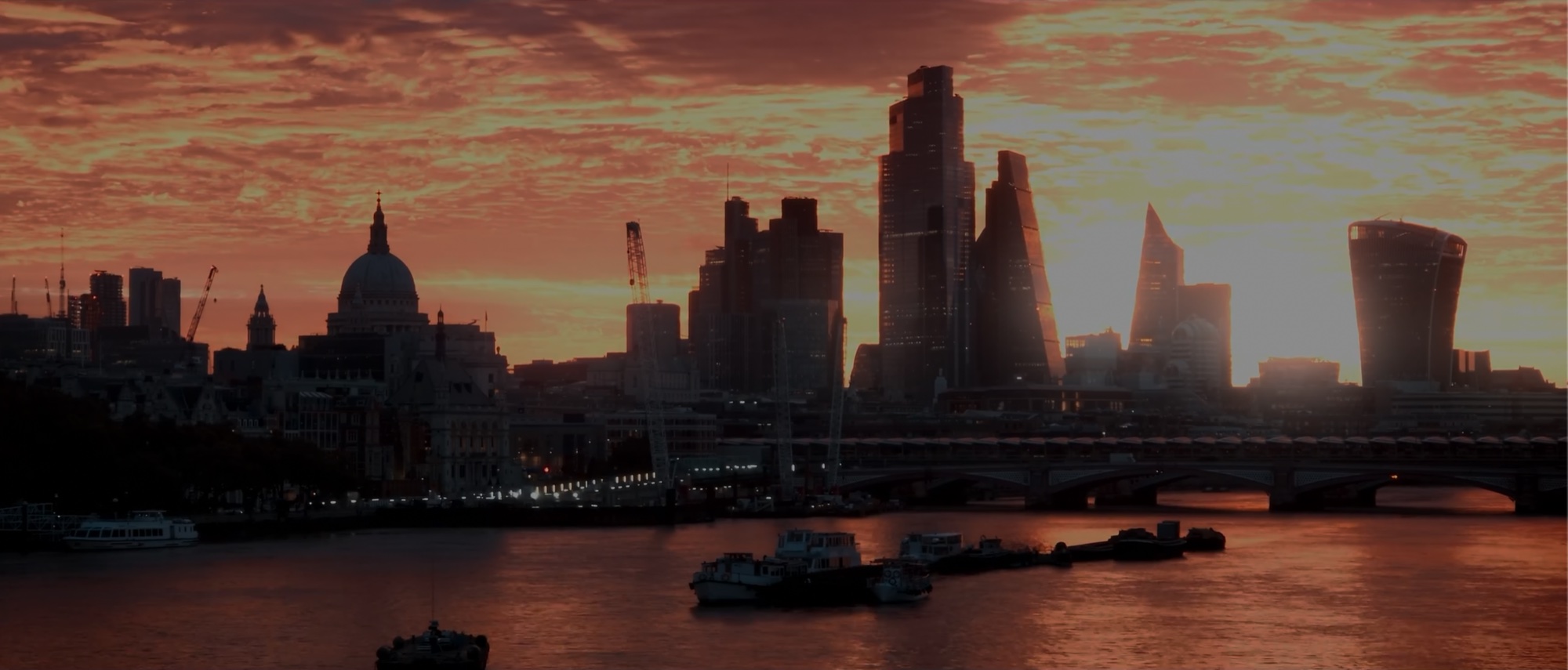 St Paul's and the City skyline under a burning orange sunset, seen across the river