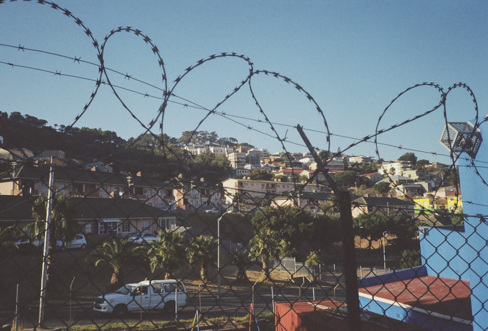 Razor wire on a fence above a township road