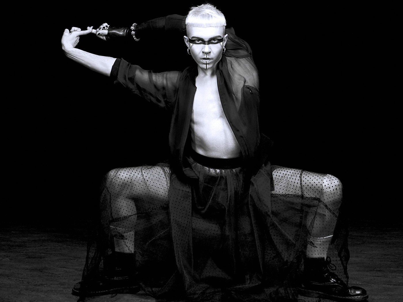 Model crouched in sheer black against a black ground, hard monochrome, from 'Where the Elevator Takes Us'