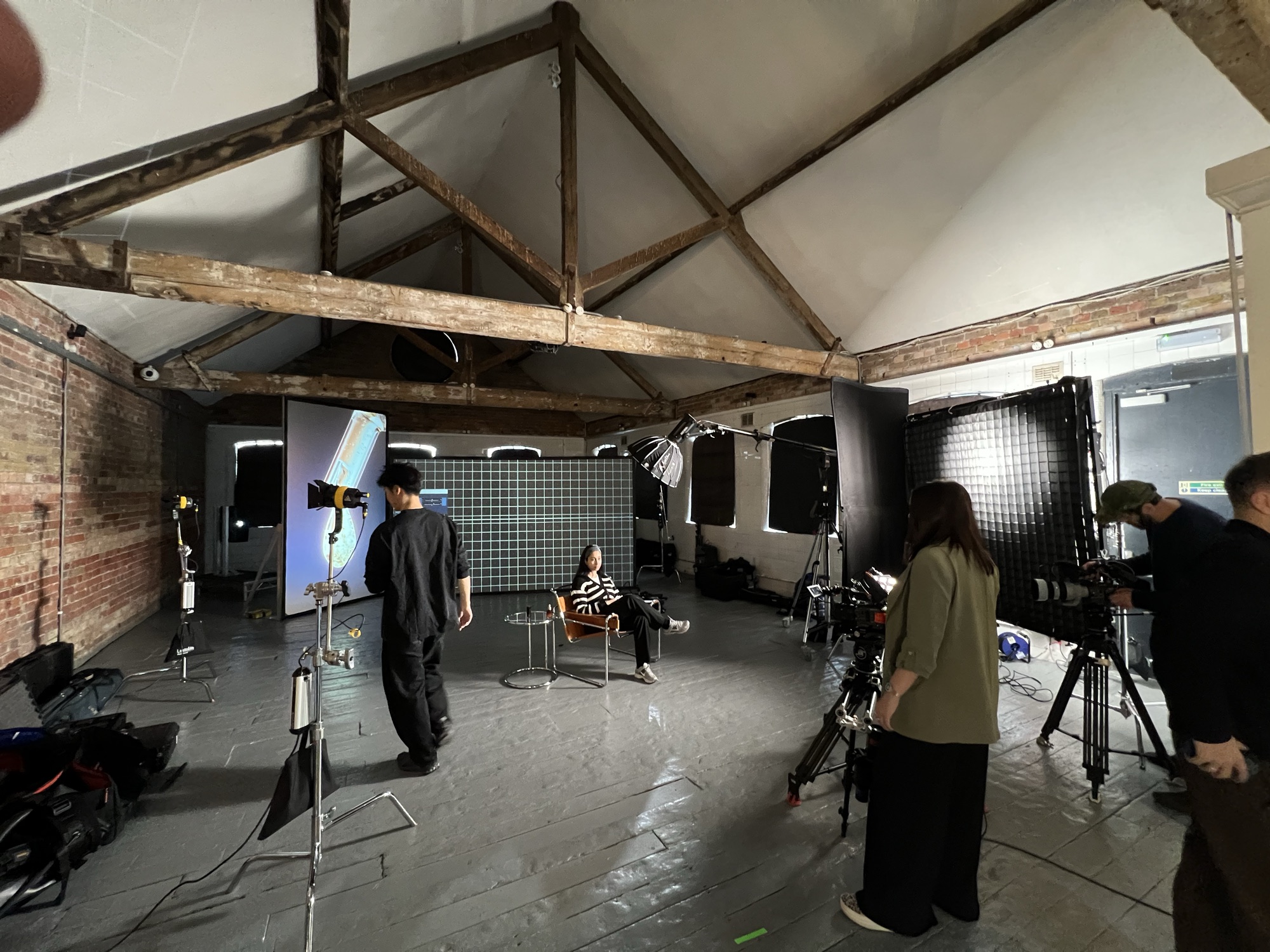 Studio wide: the interview set, projection screen and camera position in a beamed loft