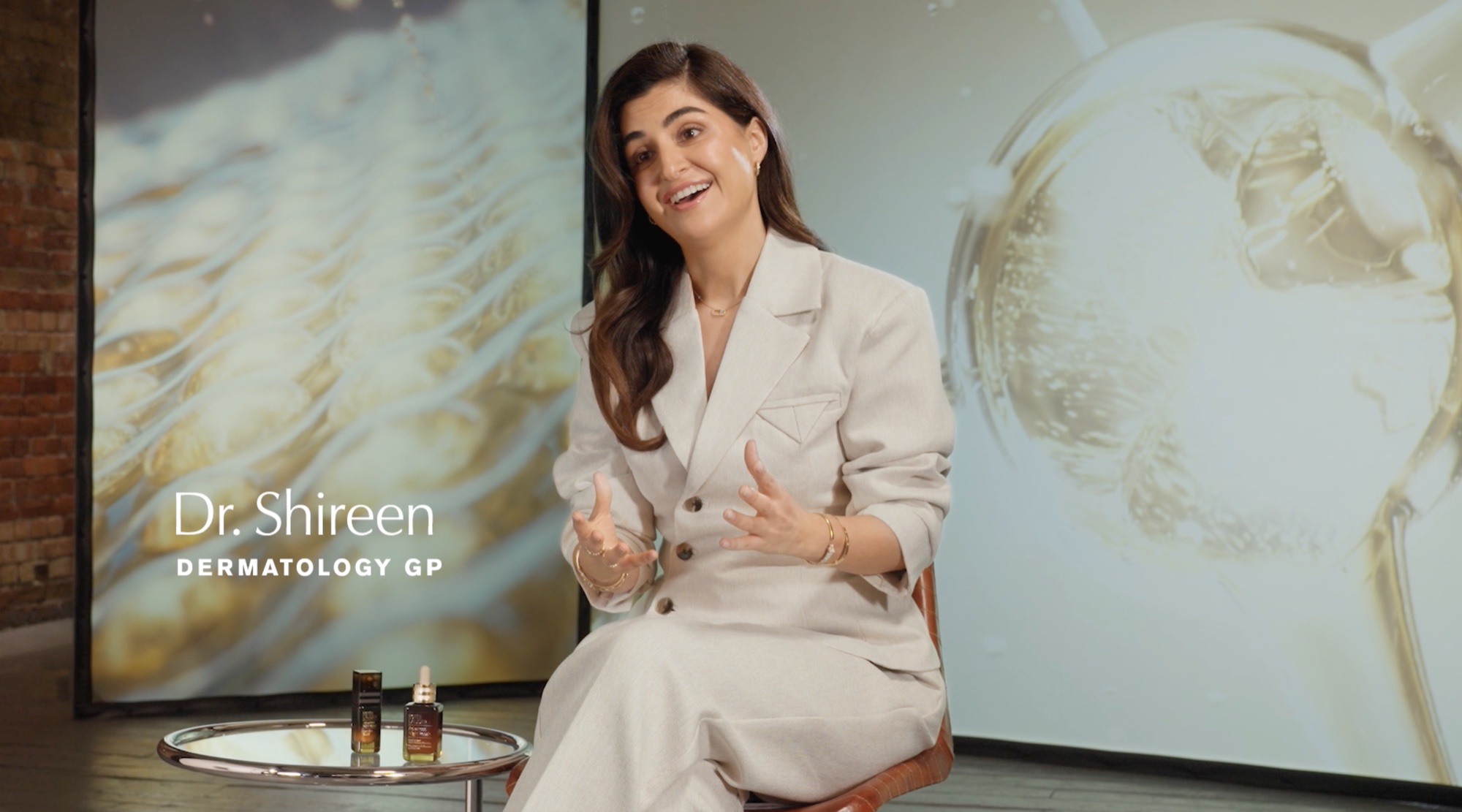 Dr Shireen, dermatology GP, mid-interview against projected serum imagery
