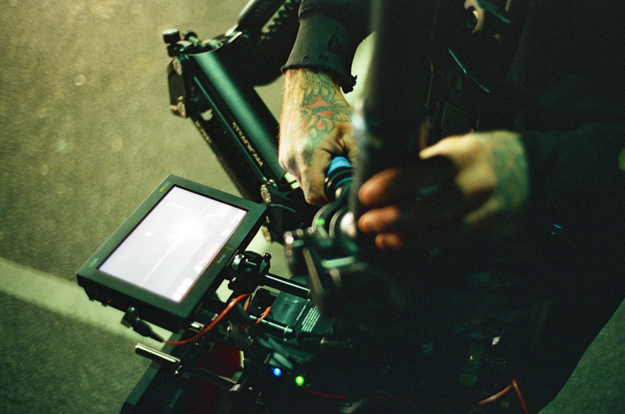 Close on the gimbal rig, monitor and hands on the camera