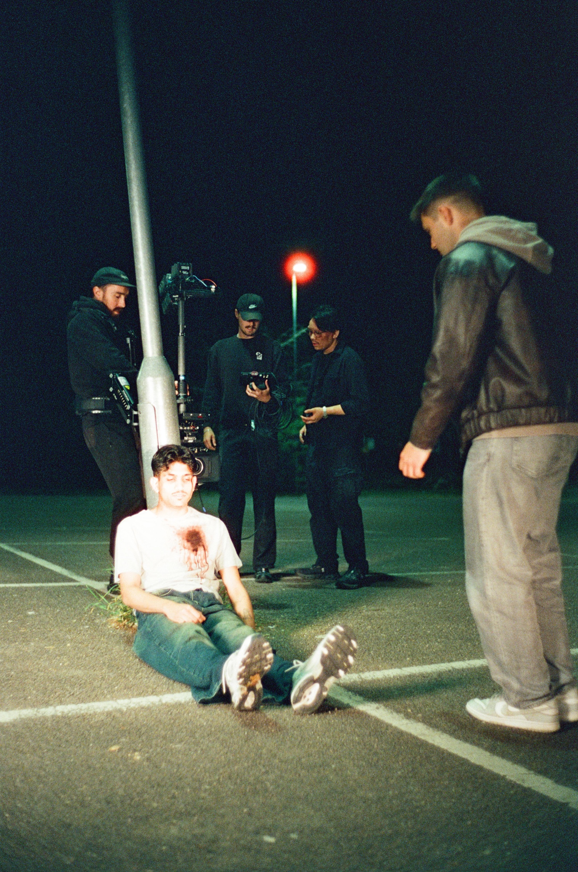 Night car park set-up with the crew around the performer