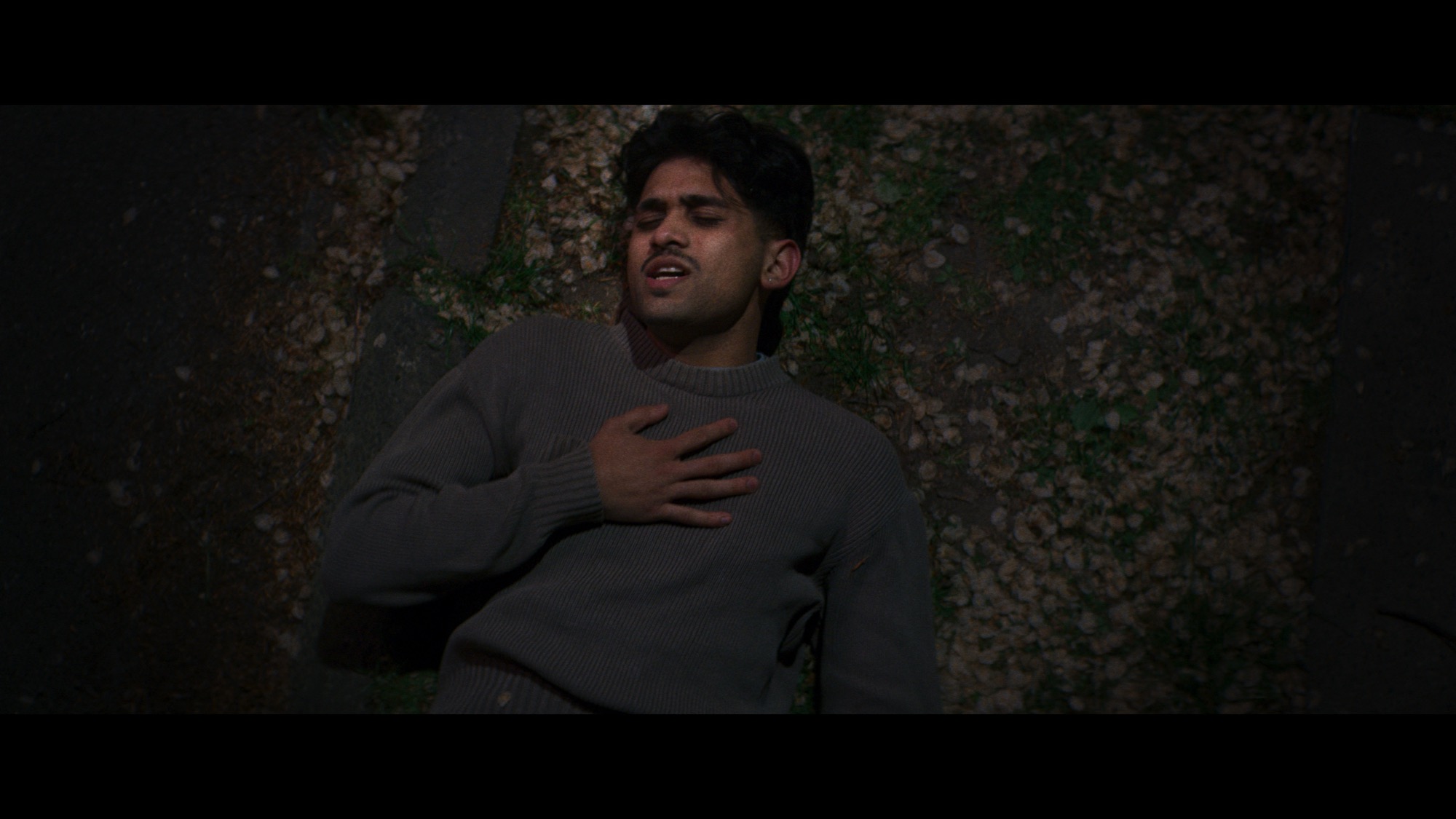 Man with a hand on his chest lying among blossom