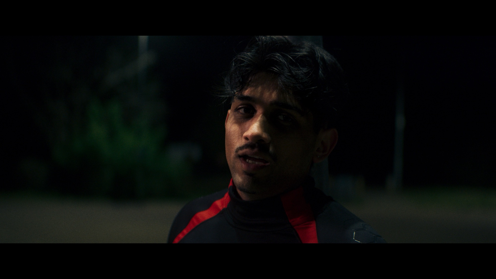 Night portrait in a red-trimmed black jacket with sodium light behind