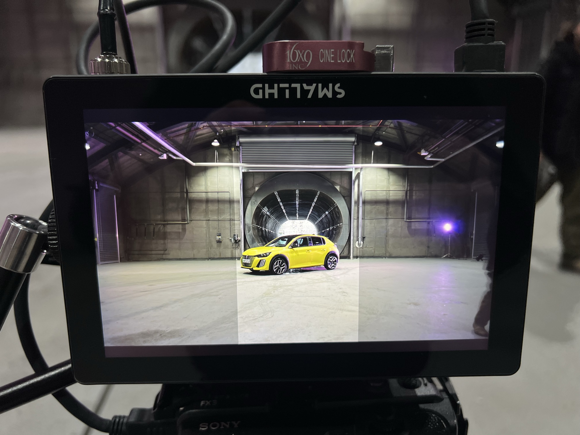 Monitor view of the yellow 208 framed in a hangar doorway