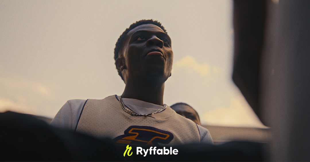 Young man in a Lakers jersey looking up, London terraces behind, from the Ryffable promo